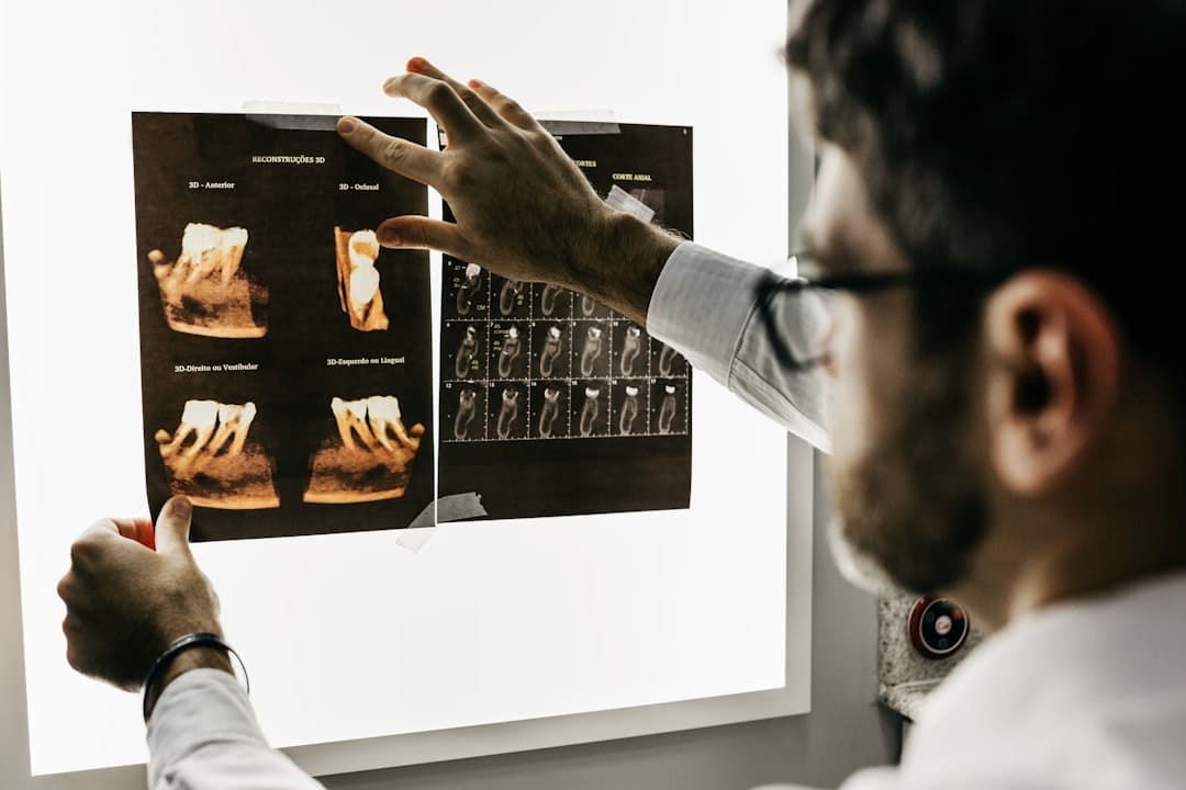 A dentist examining dental X-rays on a light box